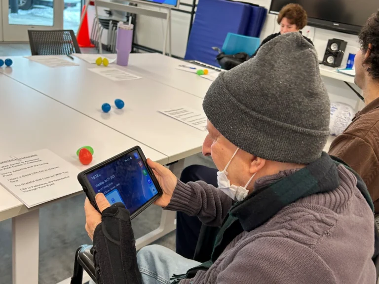 An older gentleman with a wrist brace using an iPad