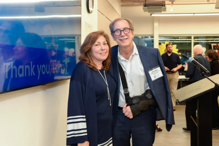 Linda and President Larry in front of a screen saying Thank you