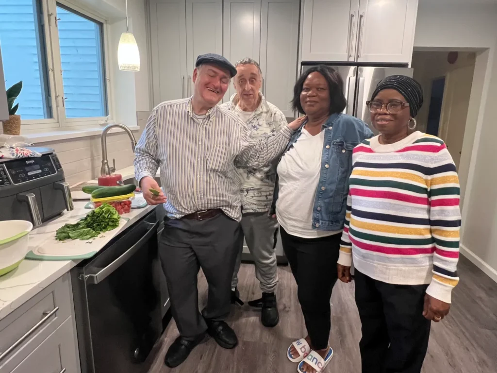 Two residents with Dina and Kari near a sink with washed vegetables